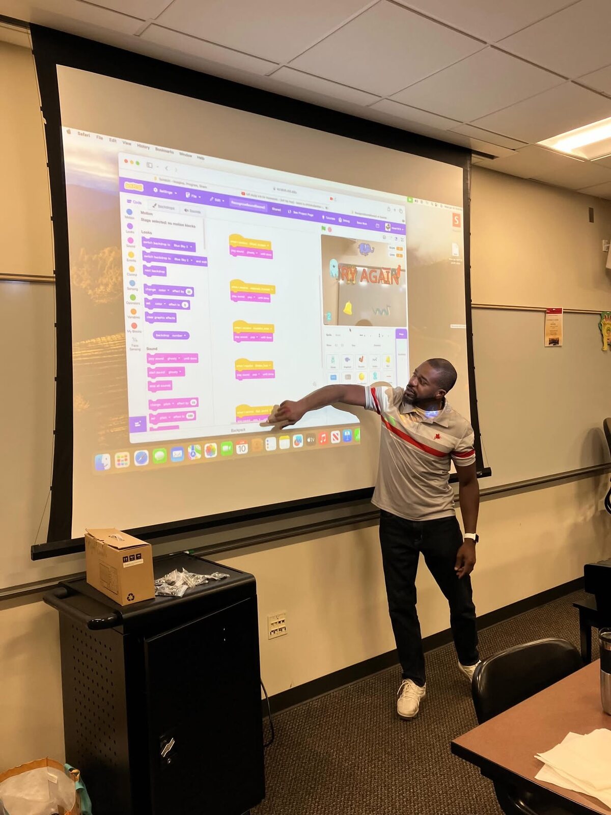 An instructor teaching Scratch on a projector